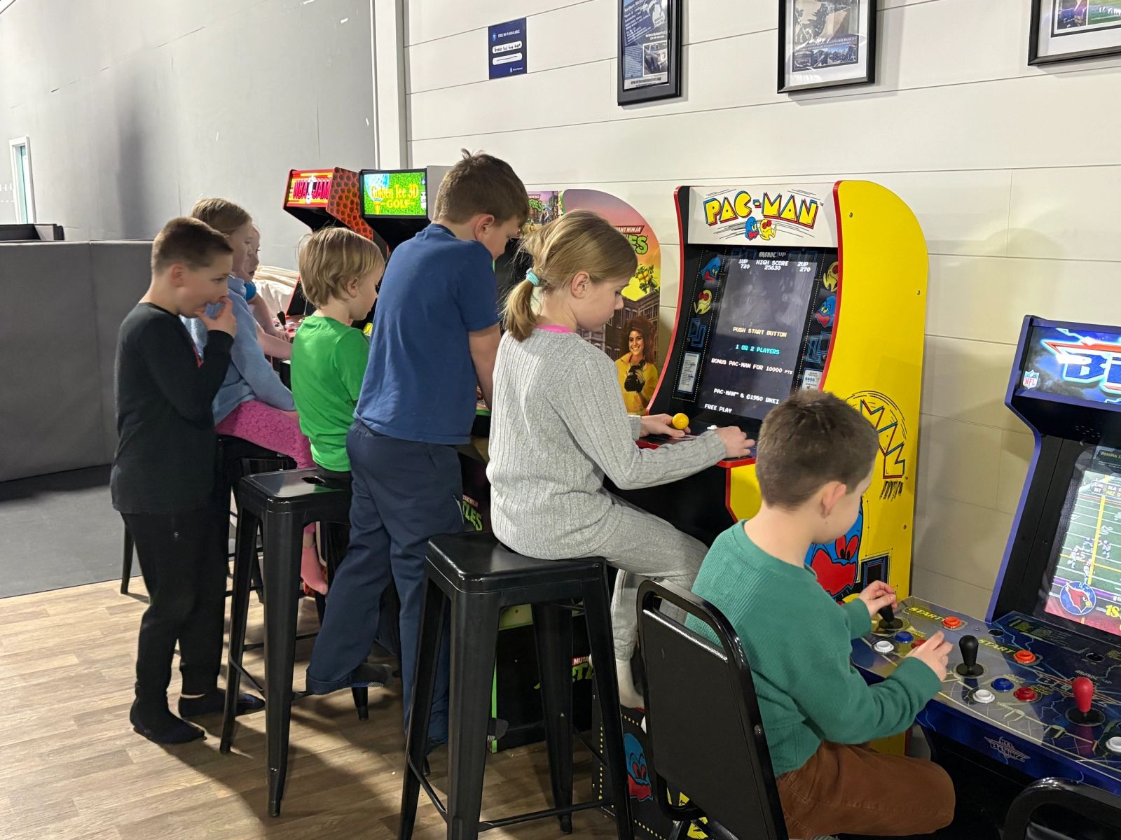 Kids playing classic arcade cabinets