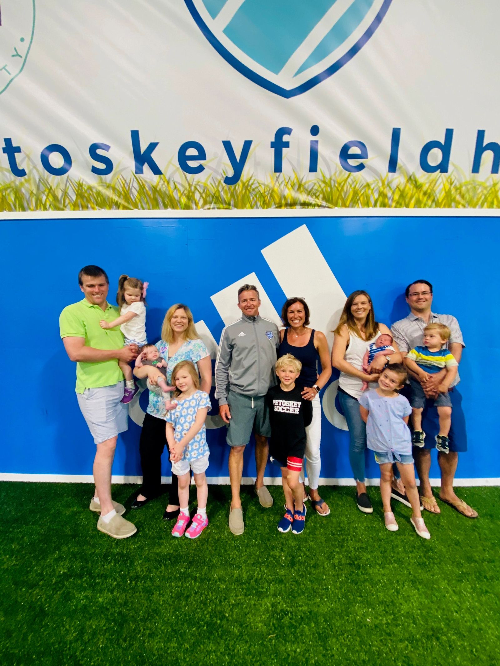 Families posing in front of the Field House wall
