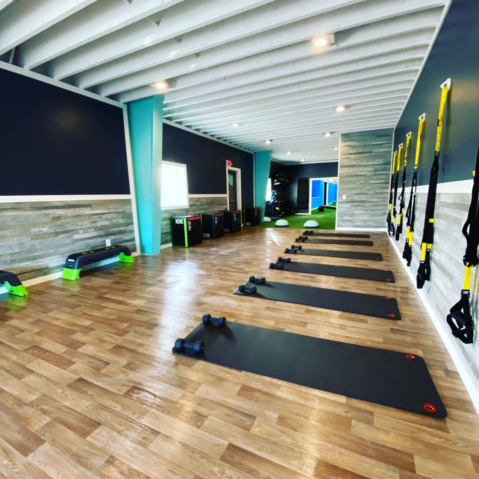 HŌM Fitness gym floor with mats and suspension trainers