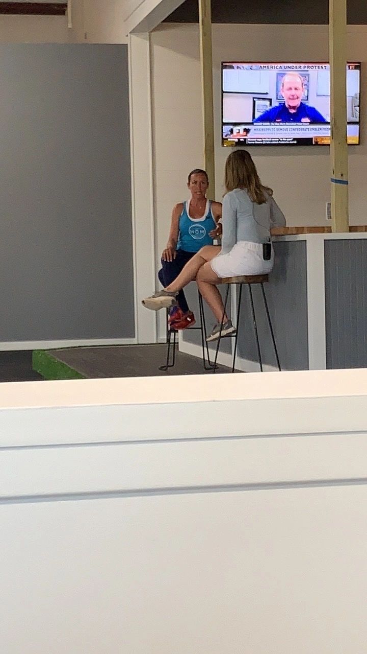 Parents sitting at a counter in the lounge watching a TV