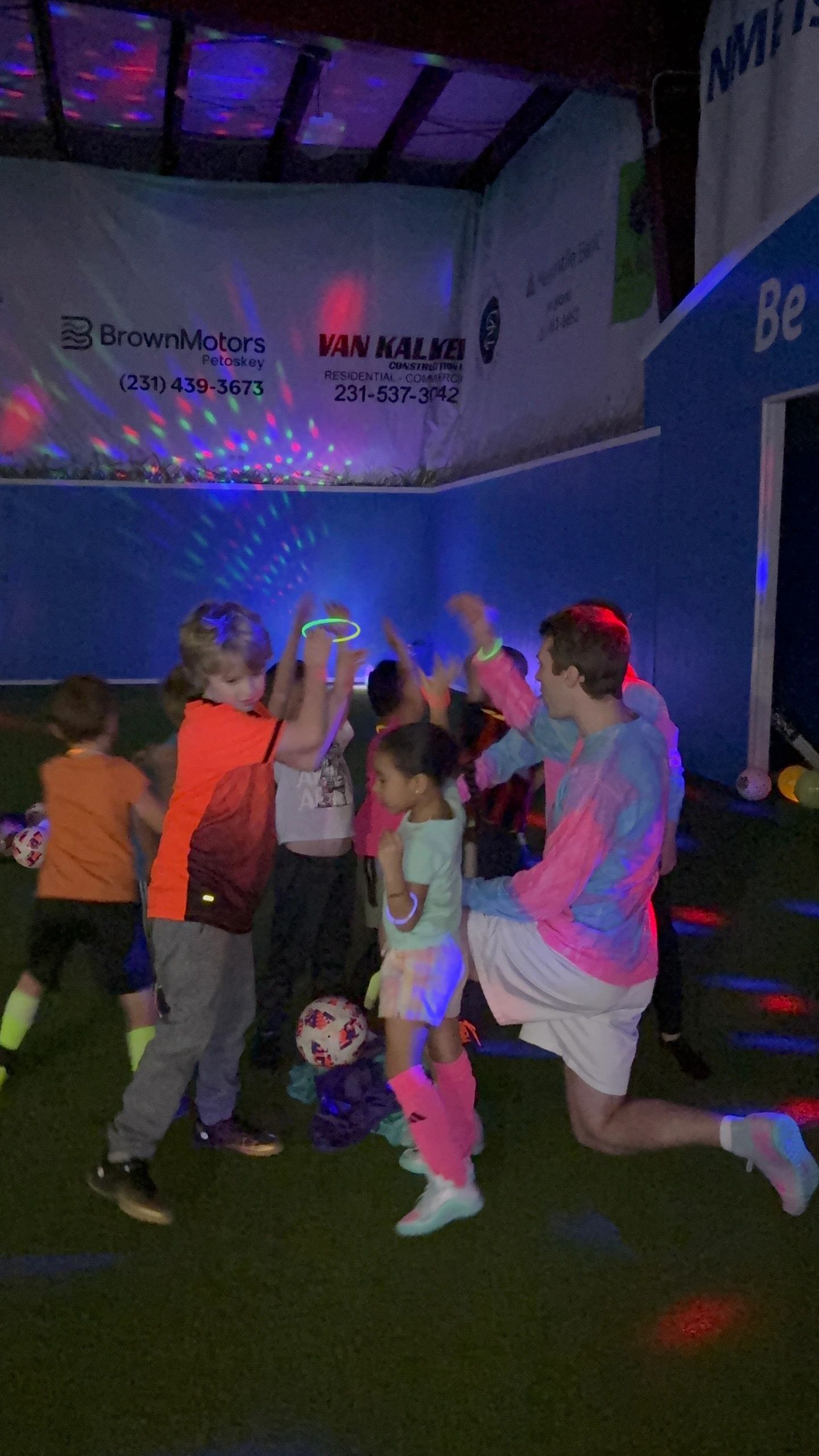 Kids dancing on the turf under party lights