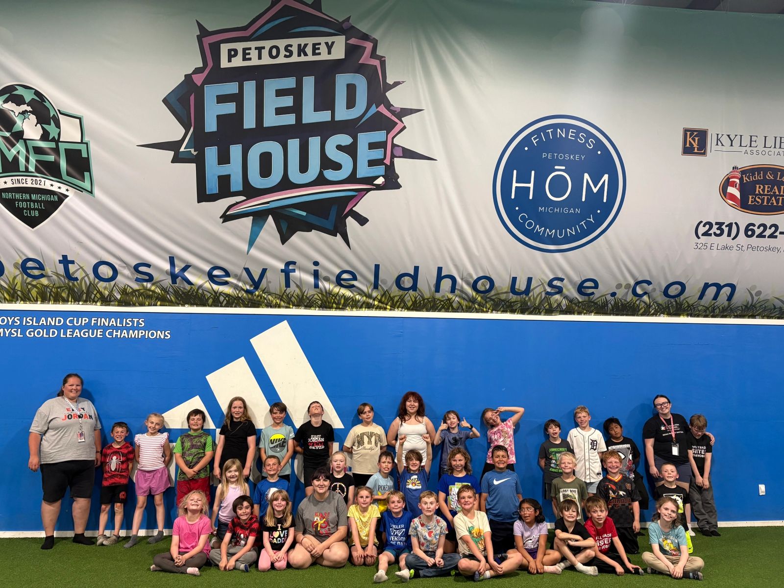 A youth soccer team posing on the indoor turf